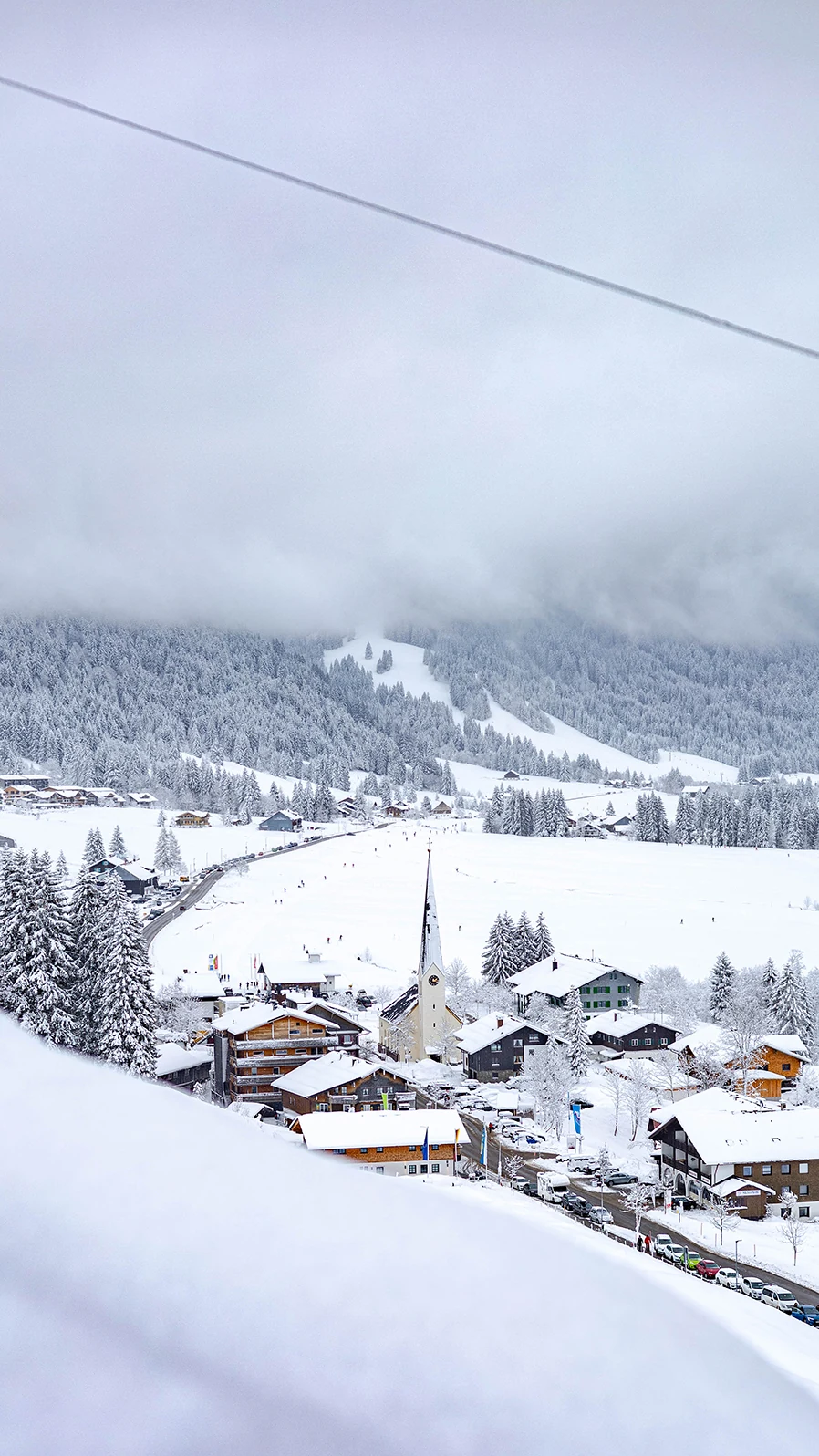Verschneites Balderschwang im Winter mit Kirche und tief verschneiten Berghängen